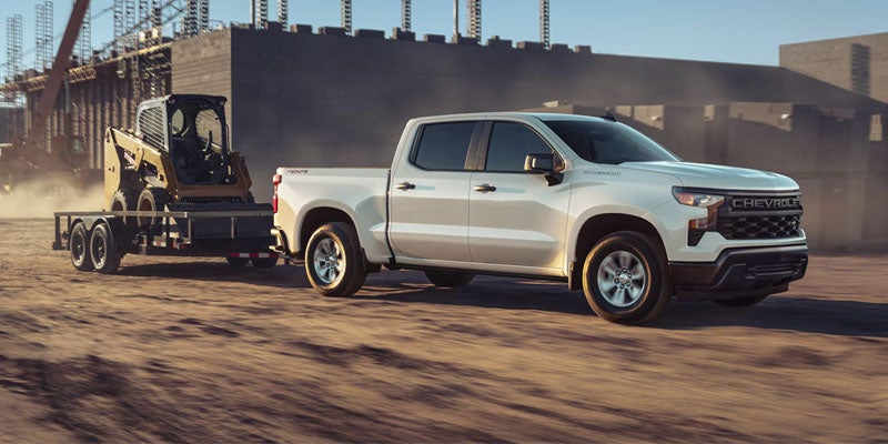 Chevrolet Silverado towing equipment trailer on construction site